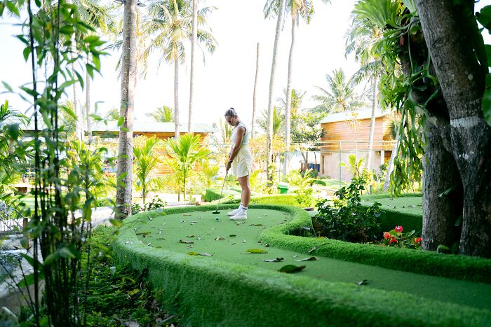 Woman Playing Mini Golf Outside 