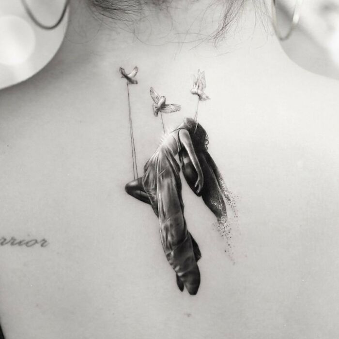 Celebrity tattoo featuring a surreal figure with birds on a Demi Lovato's back.