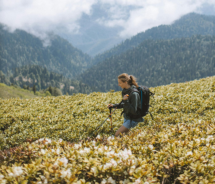 Hiker with backpack trekking through mountains, illustrating world travelers ranking friendliest and most unwelcoming nations.