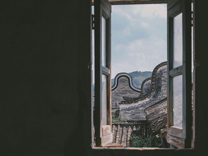 View of traditional curved rooftops through an open window, illustrating world travelers ranking friendliest nations.