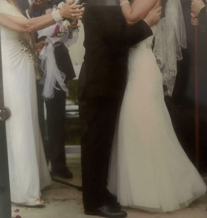 A couple embracing at a wedding ceremony with onlookers, highlighting a chaotic wedding moment.