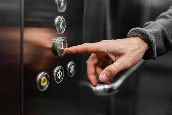 Finger pressing elevator button, illustrating basic knowledge concepts.