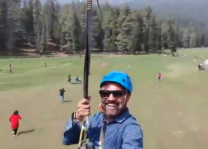 Tourist smiling while zip-lining over a field as a horrifying viral video captures mass tragedy below.