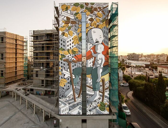 Mural by Italian artist transforms city walls into whimsical worlds, featuring large figures and vibrant urban scenes.